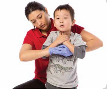 Une femme portant un chandail rouge fait une manoeuvre pour aider un enfant qui s'étouffe en faisant des poussées thoraciques