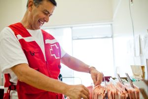 Une bénévole de la Croix-Rouge canadienne sourit en faisant du classement de dossiers