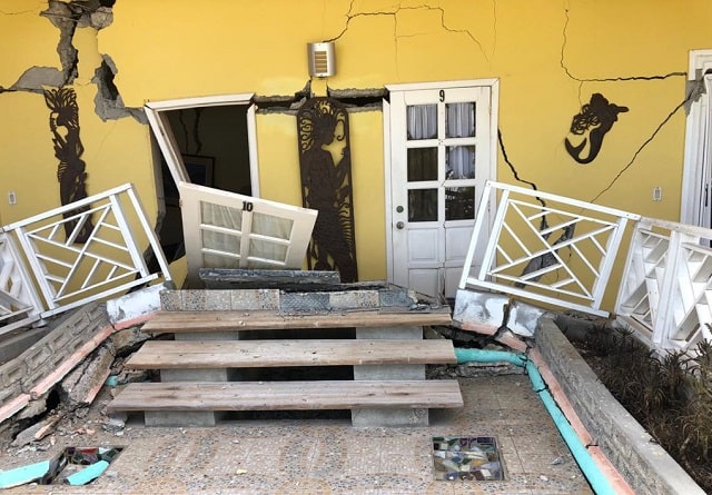 Une maison jaune en ruines après le tremblement de terre