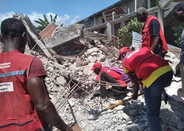 Les membres de la Croix-Rouge fouillent les décombres