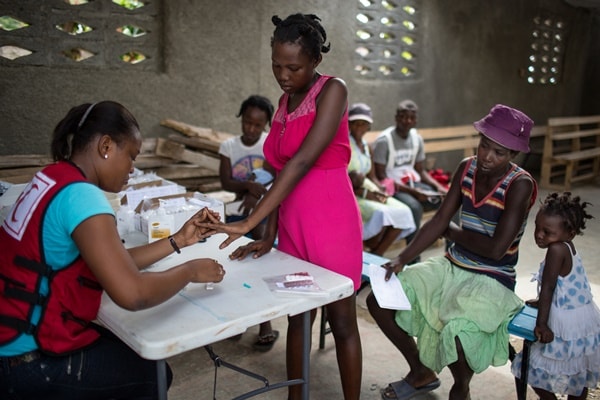 Une infirmière de la Croix-Rouge haïtienne effectue une prise de sang