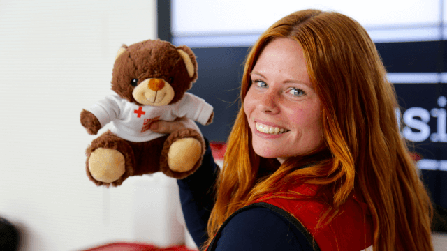 Rachel tenant un ours en peluche à l'aéroport international de Fort McMurray.