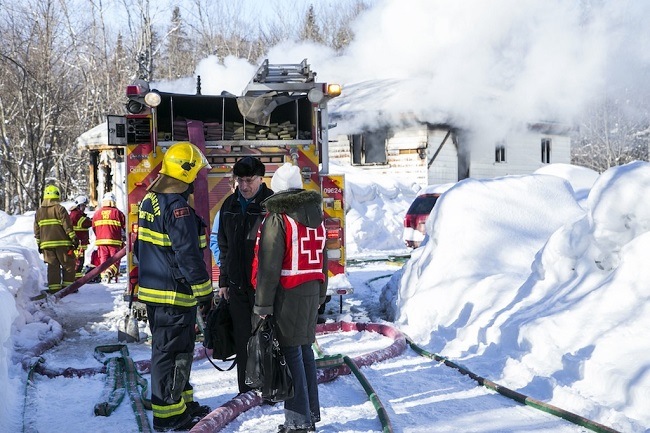Firefighter talks to Canadian Red Cross responder following a house fire Un pompier discute avec un répondant de la Croix-Rouge canadienne suite à un incendie à la maison