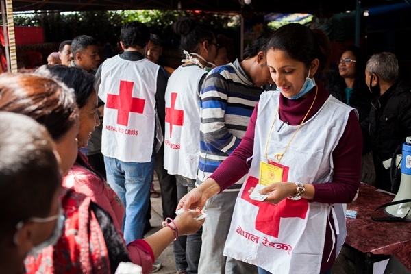 Des bénévoles Croix-Rouge distribuant des comprimés de purification d'eau