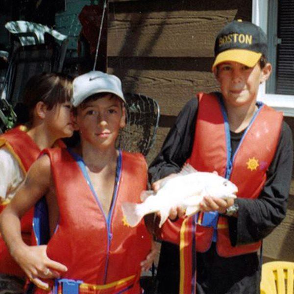 Deux garçons tiennent un poisson qu'ils ont pêché