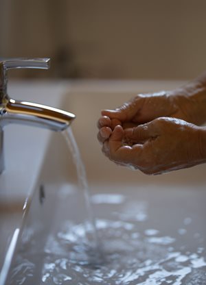 Des mains savonneuses sous un robinet