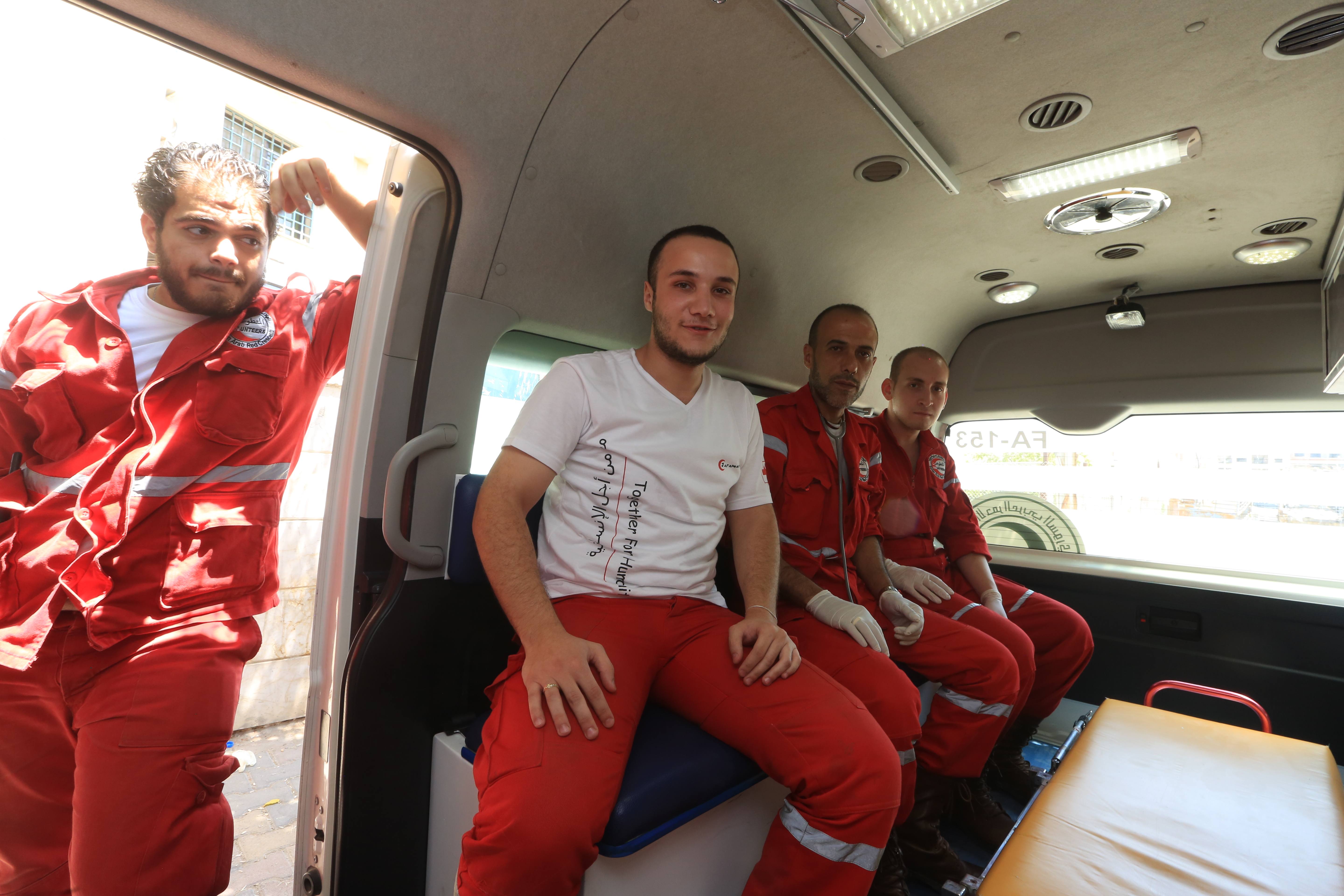 Des bénévoles du Croissant-Rouge arabe syrien s'apprêtent à partir en ambulance pour une mission d'aide dans le région rurale de Damascus 