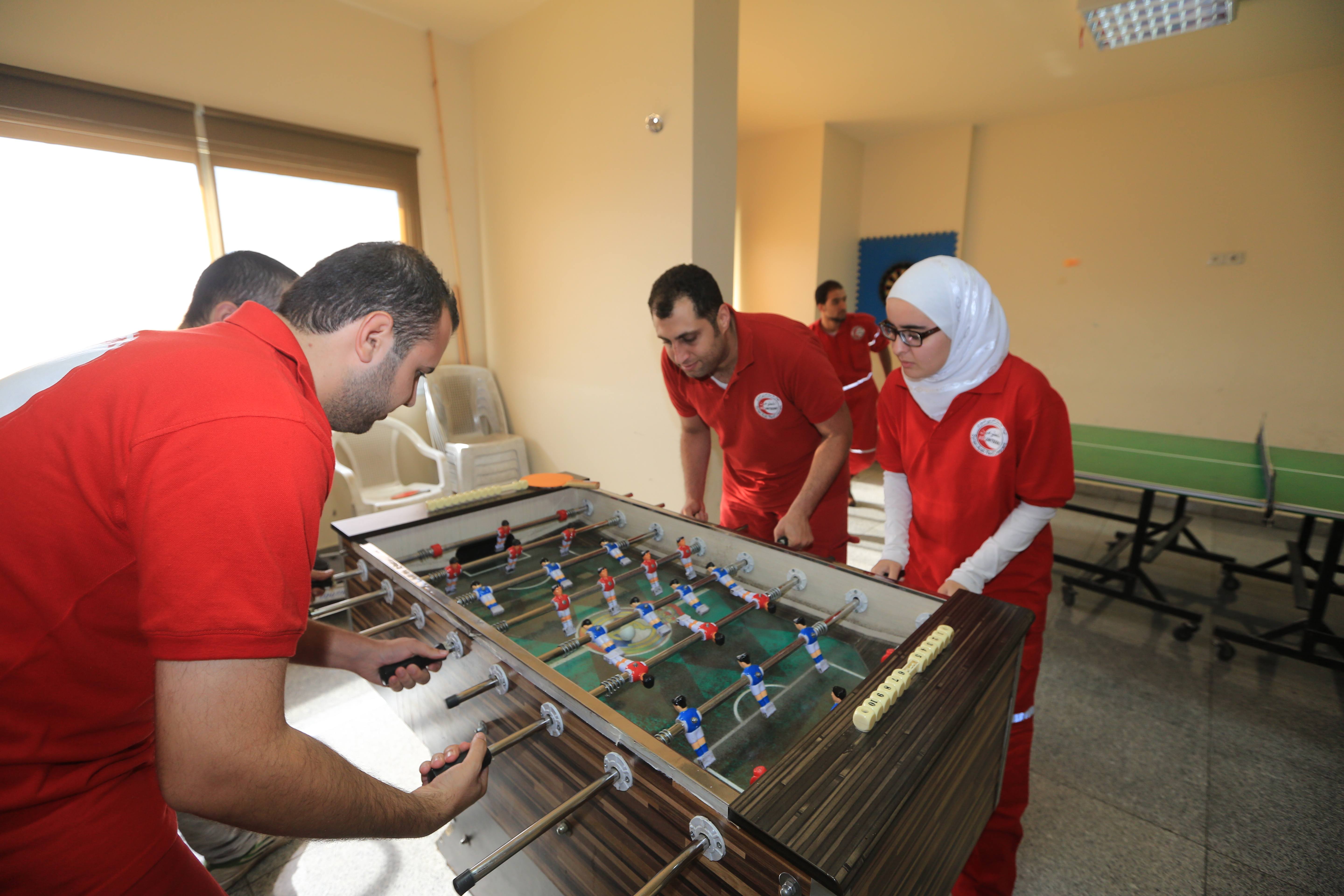 Des bénévoles profitent de leur pose pour jouer au soccer de table au centre d'opérations d'urgence de Damascus à al-Zahira. 