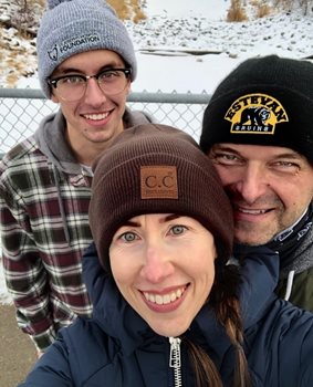 Mark et ses parents sourient à la caméra en prenant une selfie.