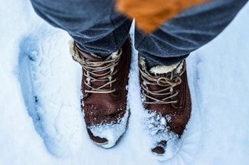 Une paire de bottes brunes recouvertes de neige