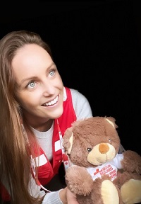 Kate tient un ourson en peluche de la Croix-Rouge