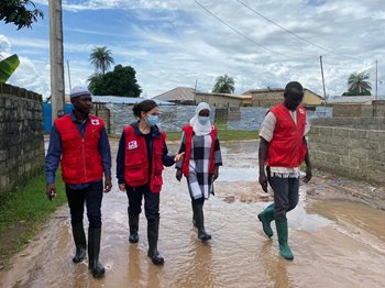 Sarah Parisio marche avec 3 collègues de la Croix-Rouge dans une rue inondée