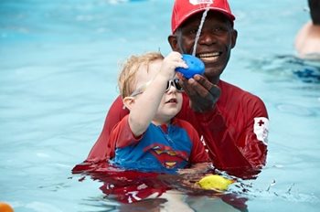 Barney avec un enfant dans une piscine