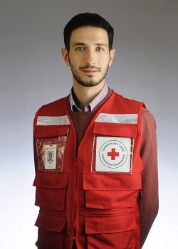 Rateb Fouad regarde la caméra et porte une veste de la Croix-Rouge