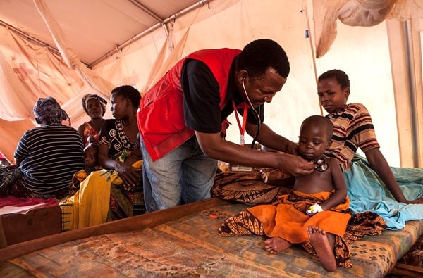 Un docteur de la Croix-Rouge de Tanzanie soigne un enfant du Burundi