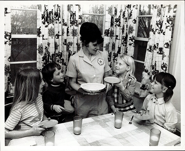 Croix-Rouge Homemaker Mme Renate Pedley servir tarte et du lait pour les enfants de son client Mme Hall, le 30 mai 1973.