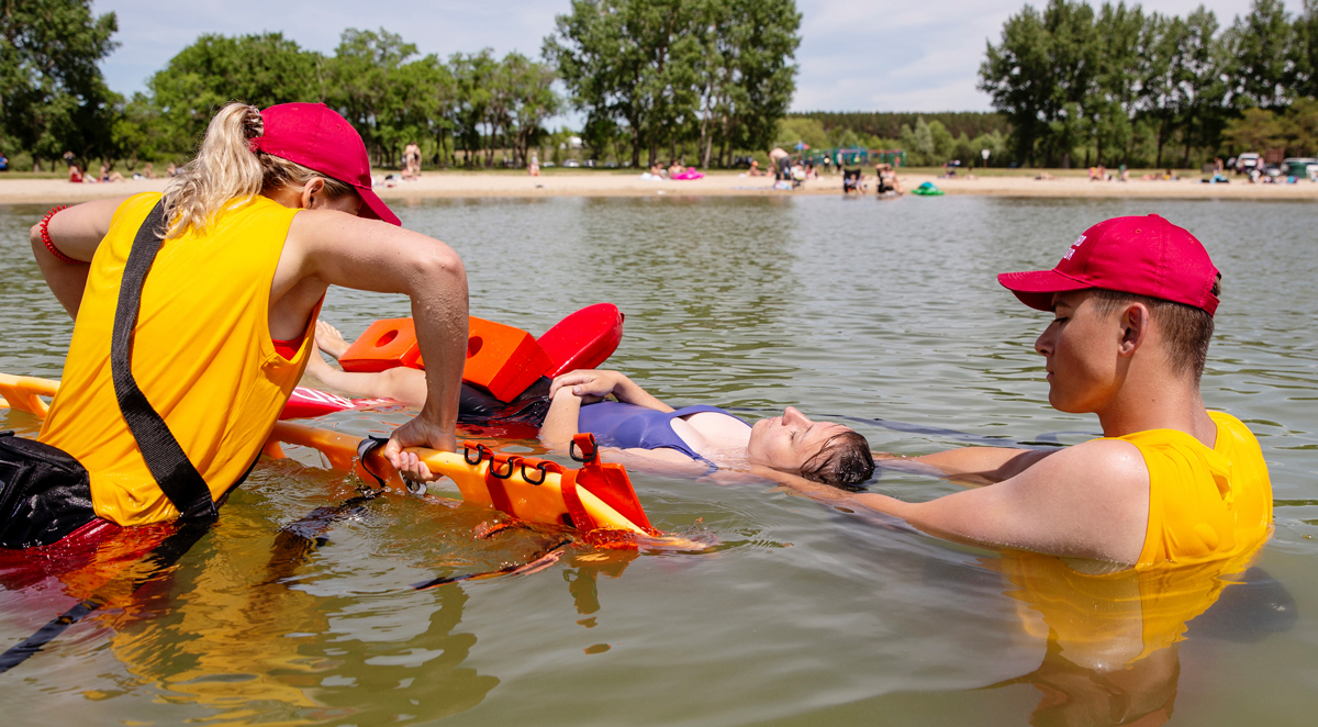 Deux sauveteurs effectuant un exercice de sauvetage sur une personne flottant dans un lac.