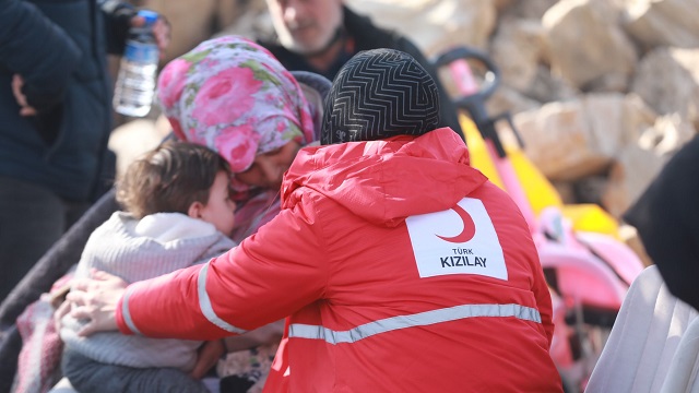 Un benevole du Croissant-Rouge turc aide une famille