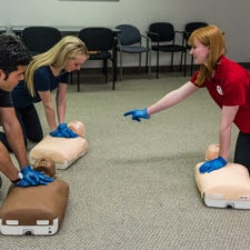 CPR instructor practicing with two students