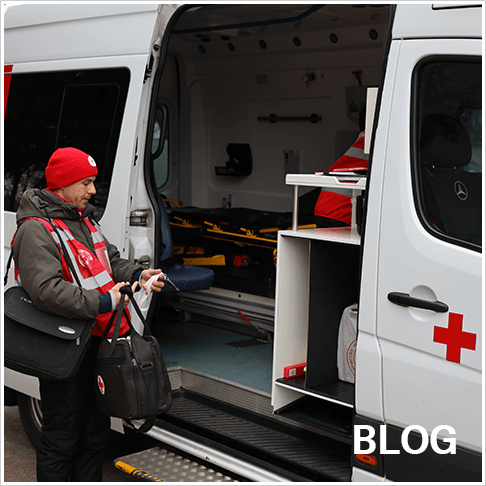 Membre de la Société de la Croix-Rouge d’Ukraine à côté d’une unité de santé mobile à Mytlashivka.