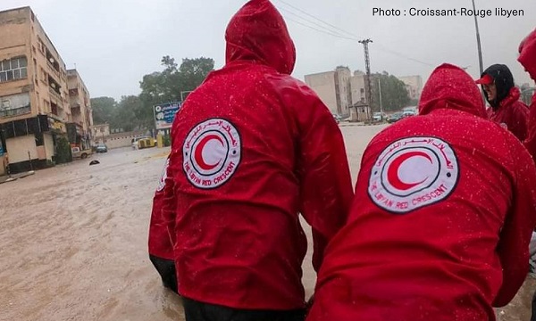 Des bénévoles du Mouvement de la Croix-Rouge et du Croissant-Rouge tentent de se frayer un chemin dans les eaux de crue. 
