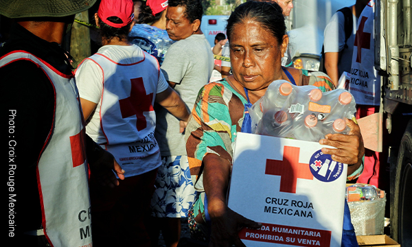 Une personne transporte une boîte arborant le logo de la Croix-Rouge mexicaine, après le passage de 