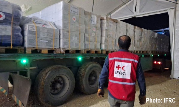 Un employé de la Fédération internationale supervise l’arrivée d’un camion chargé d’aide humanitaire au Moyen-Orient.