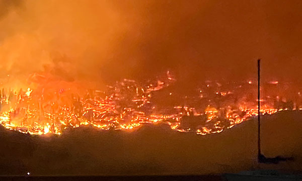 Vue à vol d'oiseau d'un gigantesque incendie de forêt - flammes orange et fumée écrasante - qui ravage une partie de la Colombie-Britannique.