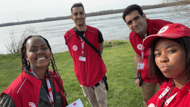 Un groupe de quatre bénévoles de la Croix-Rouge au bord d'un lac