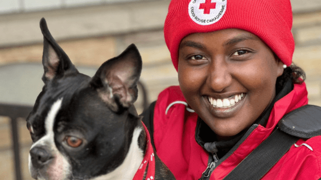 Une bénévole de la Croix-Rouge de collecte de fonds face à face souriant en tenant un chien