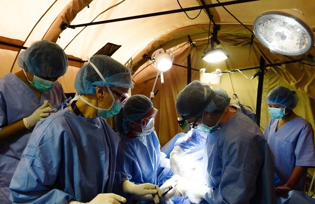 Des professionnels de la santé pratiquent une chirurgie dans la salle d’opération de la clinique mobile.
