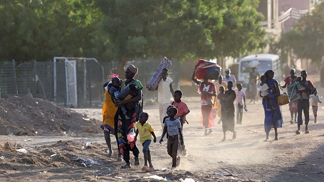 Families with young children flee with their belongings. 