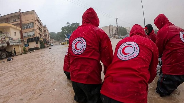 Cinq personnes aident l’équipe du Croissant-Rouge libyen lors des inondations. 