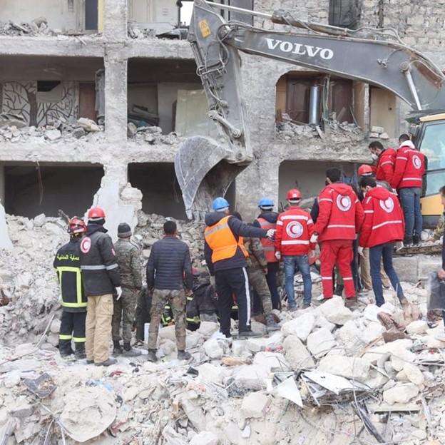 Many people including Red Crescent workers dig through rubble looking for people