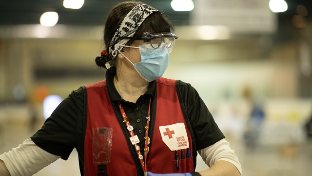 Red Cross volunteer wearing PPE, mask and gloves