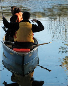 deux hommes pêchant dans un canot