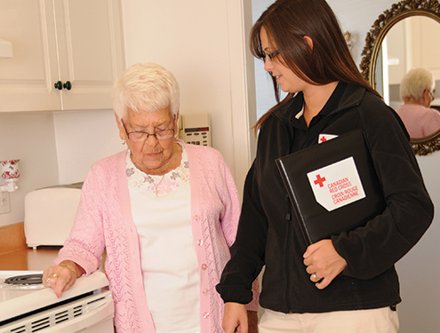 Un travailleur de la Croix-Rouge aide une femme âgée.