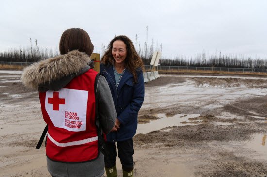 Membre de la Croix-Rouge canadienne parle avec une femme touchée par les feux de forêt Alberta 2016