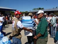 Des équipes chargées de l’approvisionnement en eau et de l’assainissement composées de membres de la Croix-Rouge dominicaine et de l’agence de gestion de l’eau du gouvernement dominicain livrent un réservoir d’eau dans un abri à Saint-Domingue. 