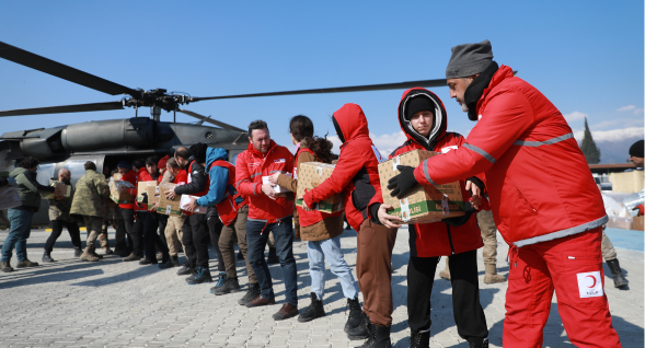 Des travailleurs du Croissant-Rouge déchargent des fournitures d'un hélicoptère.