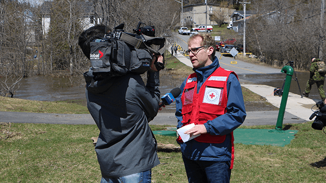 Un représentant de la Croix-Rouge canadienne en s'entretient avec un caméraman de Global News.