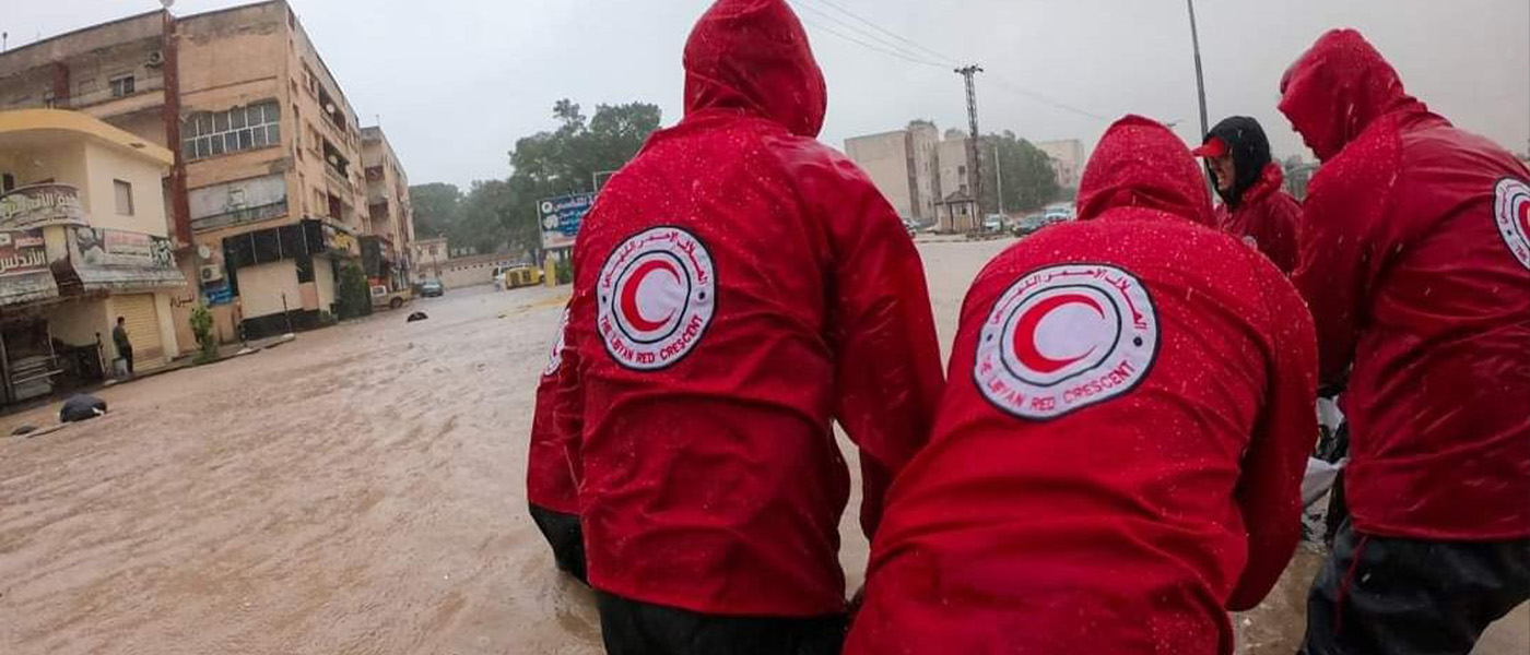 Des bénévoles du Mouvement de la Croix-Rouge et du Croissant-Rouge tentent de se frayer un chemin da