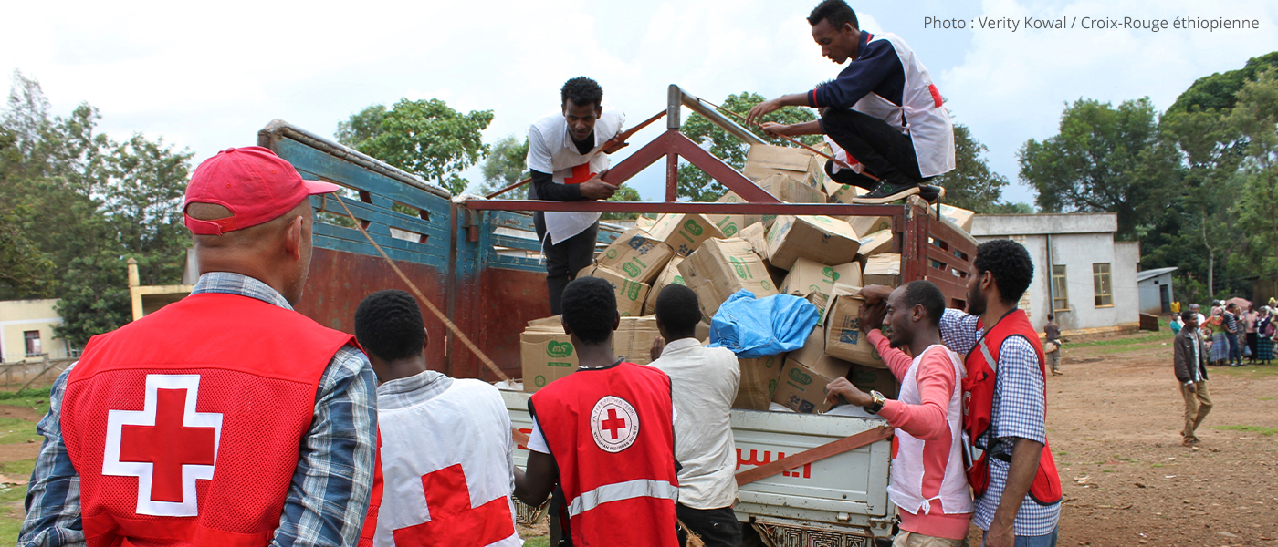 Des employés et des bénévoles de la Croix-Rouge déchargent du matériel d'un camion.