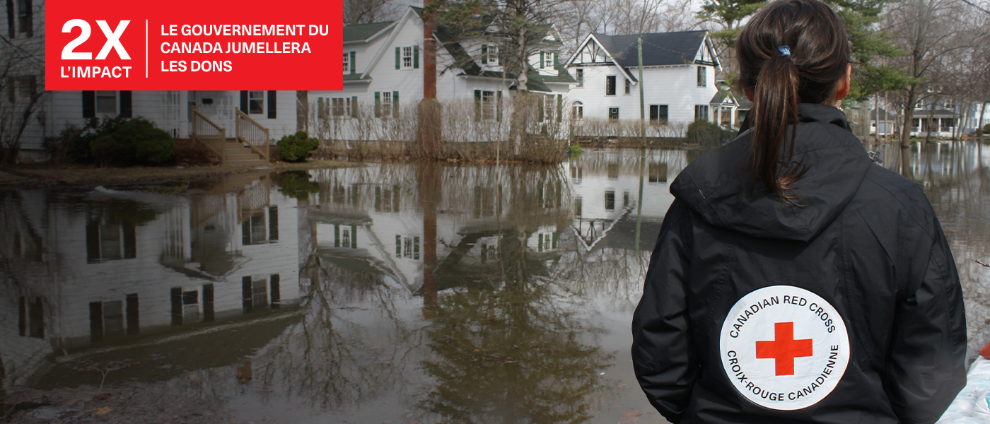  Bénévole du CRC debout dans un quartier inondé.