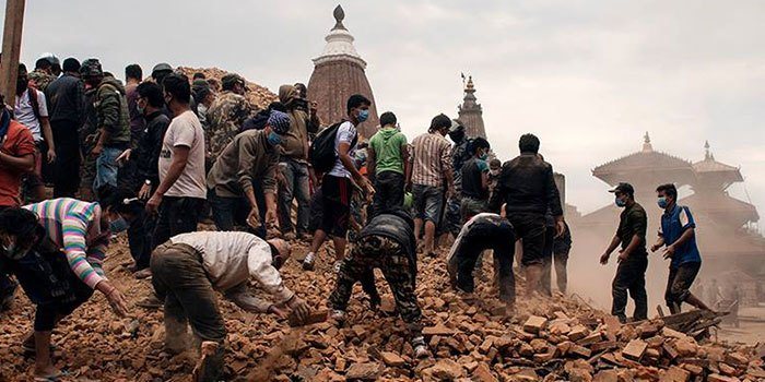 Un groupe de personnes sur une zone sinistrée après un tremblement de terre