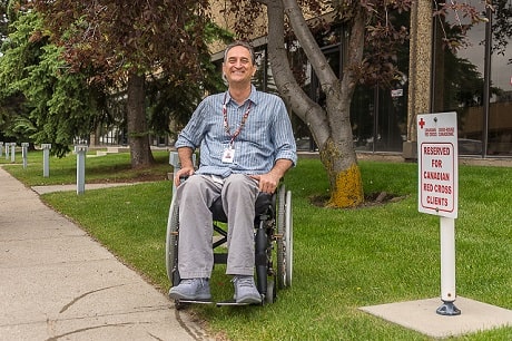 Mahmood Jafari, Croix-Rouge canadienne, assis dans son fauteuil roulant et souriant. 