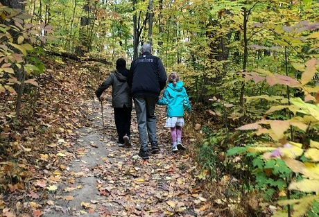 Deux enfants marchent dans la nature automnale avec leur grand-père