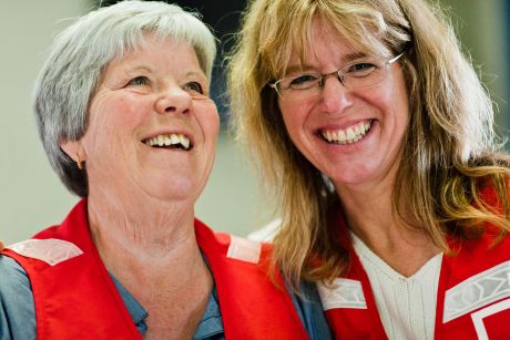 Deux bénévoles de la Croix-Rouge canadienne profitent d’un moment de rire avec un grand sourire