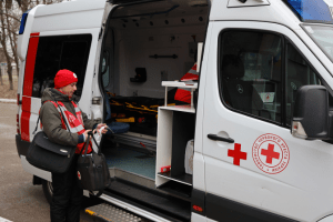 Un membre de la Société de la Croix-Rouge d’Ukraine s’apprête à déposer du matériel médical dans le véhicule d’une unité de santé mobile.
