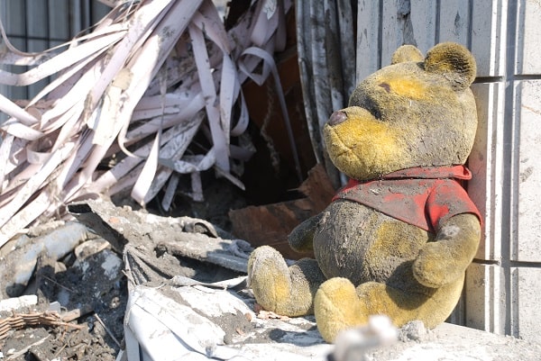 Un ourson en peluche grandeur nature dans les débris.